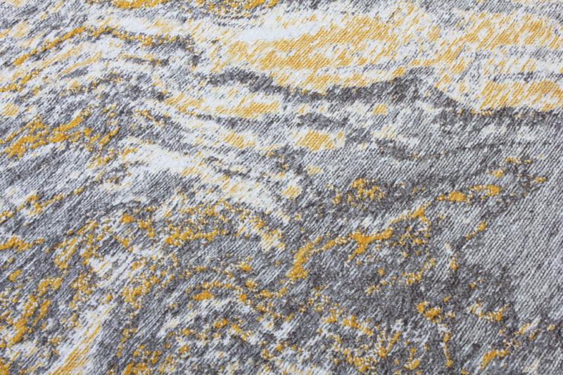 Close-up view of gray, white, and yellow abstract patterned rug