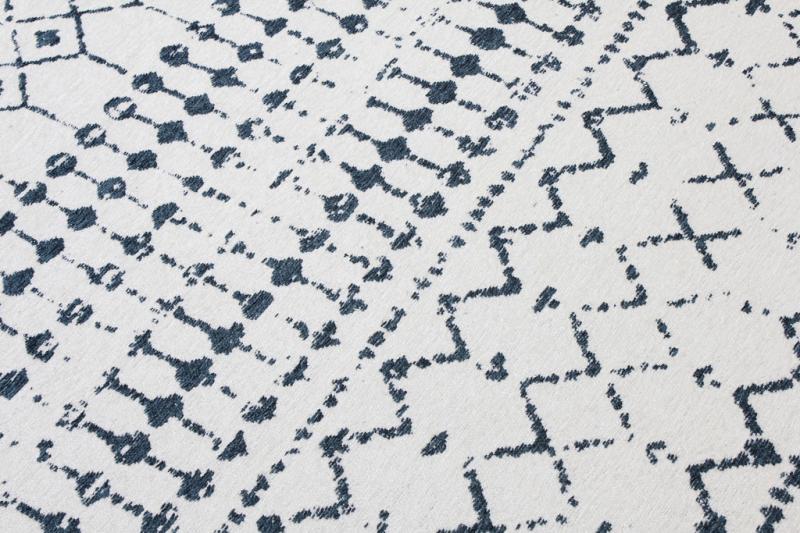 Close up view of white rug with blue geometric pattern