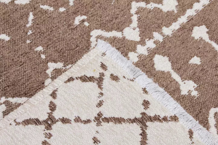 Close up view of brown and white patterned rug showing fringe
