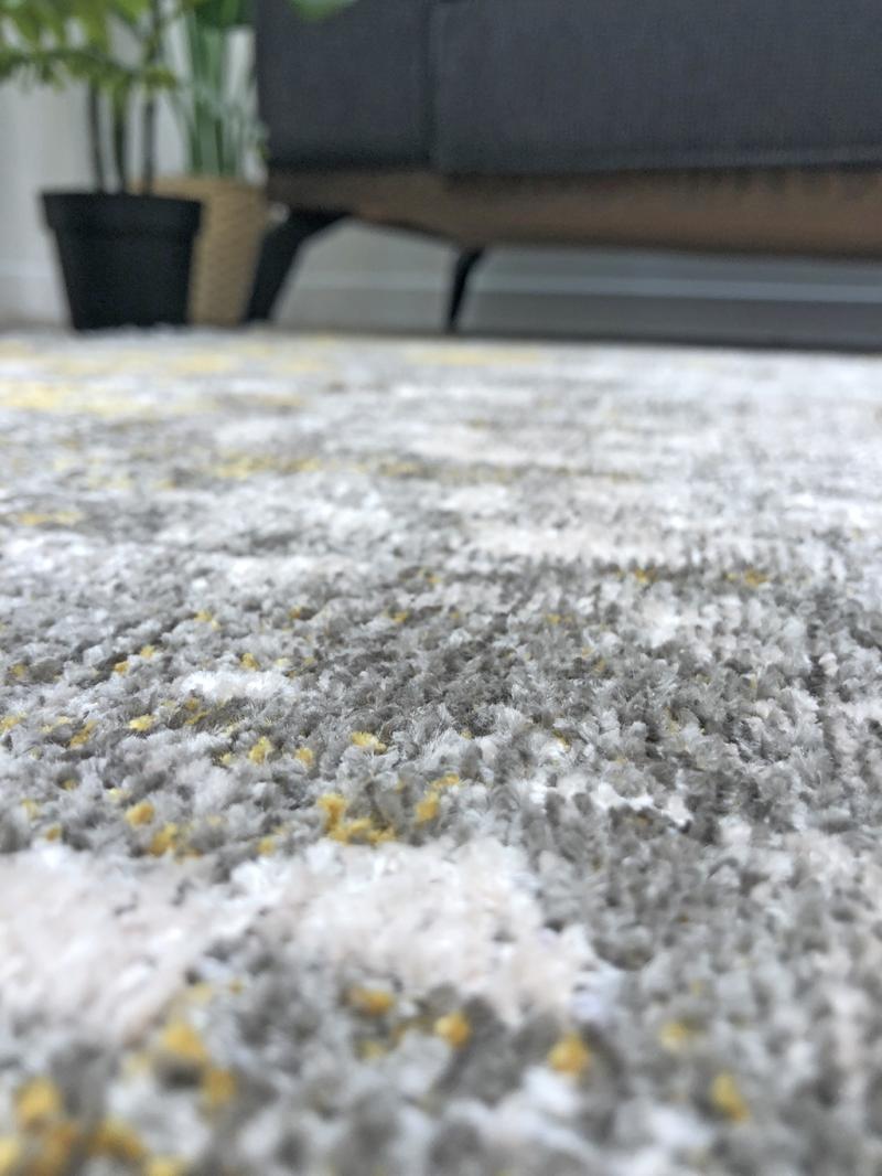 Close up view of gray white yellow patterned area rug texture