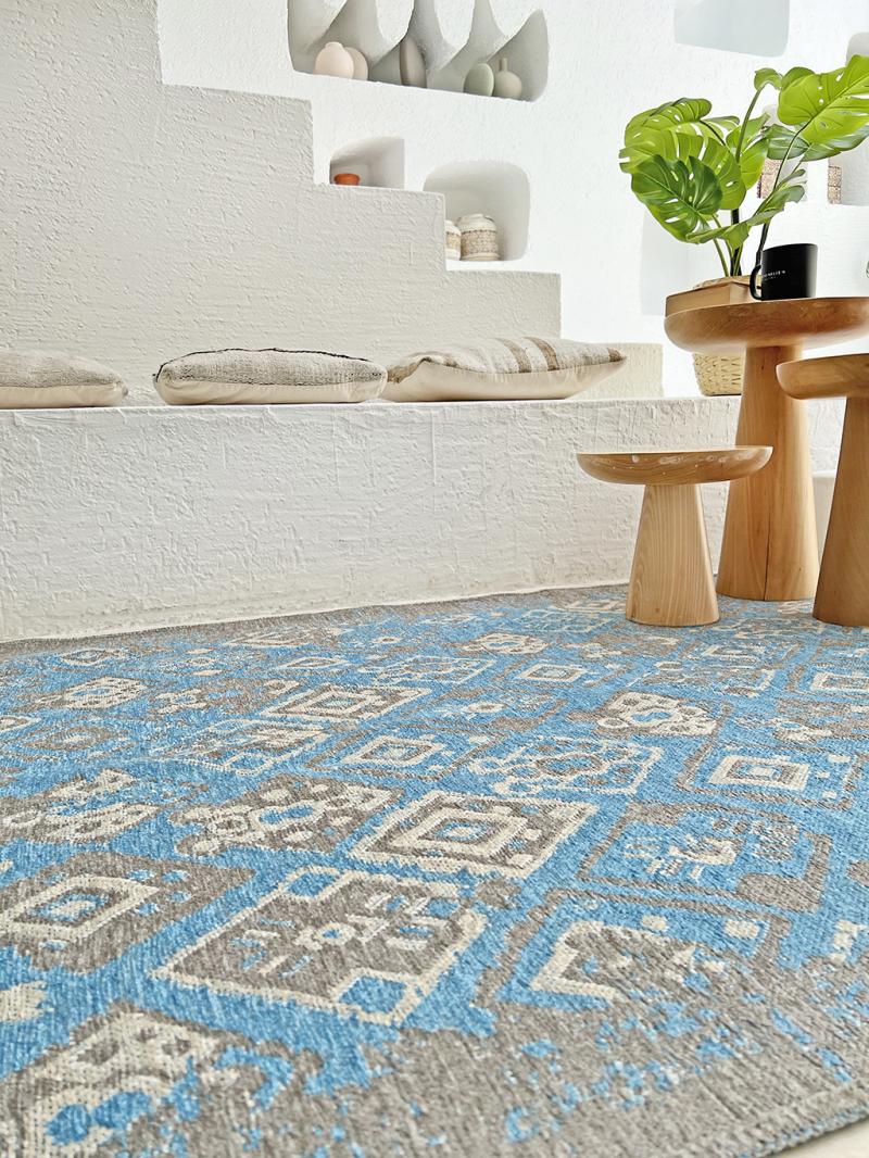 Close up view of blue and gray patterned area rug on floor