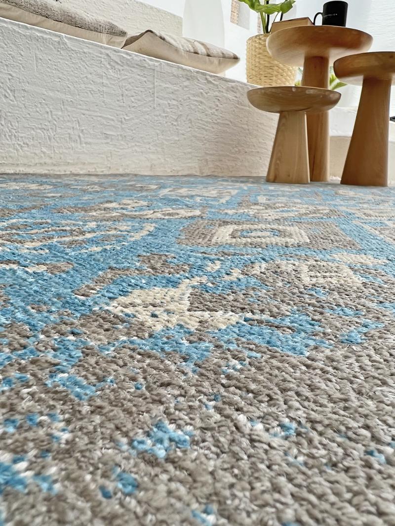 Close up view of blue and gray patterned area rug