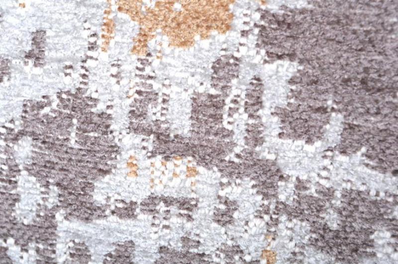 Close up view of brown white abstract patterned rug texture
