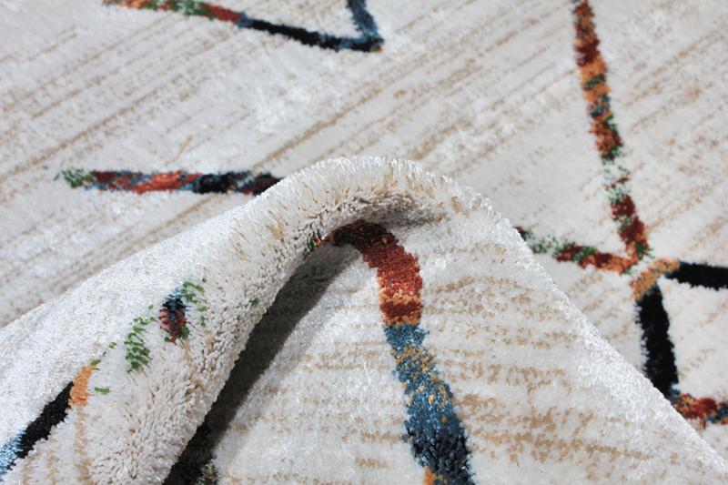 Close up view of white rug with colorful abstract pattern