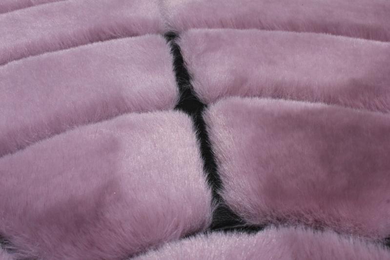 Rabbit Round Fur Rug placed in a chic bedroom, adding a touch of sophistication with its rose and black hues.