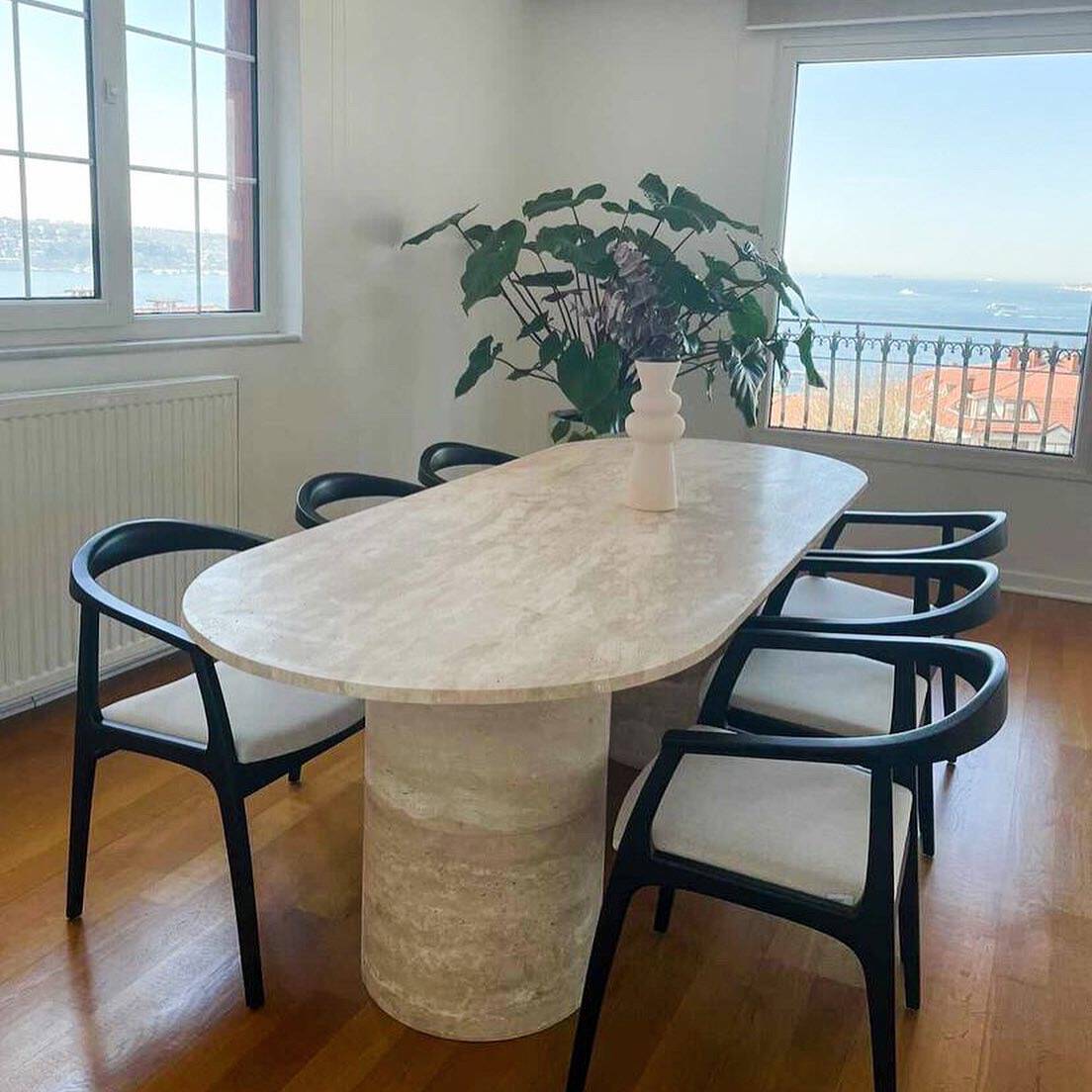 Close-up of Xiāng dining table's travertine texture and double cylinder leg craftsmanship.