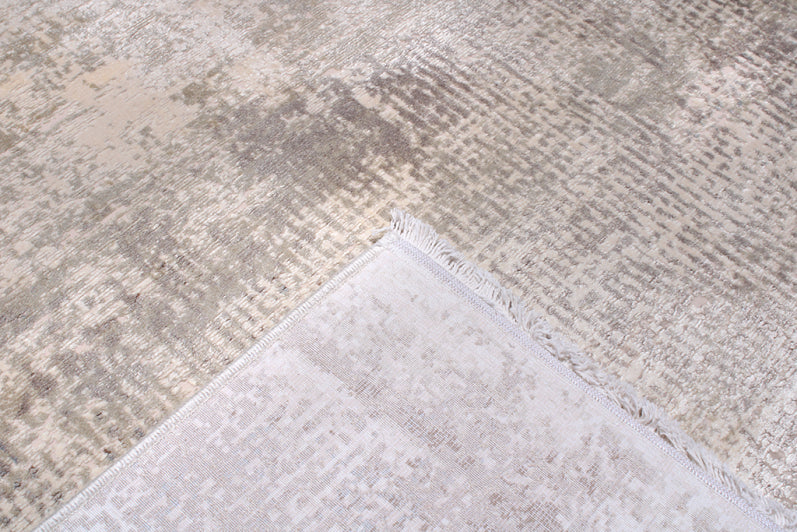 Close up view of beige and gray patterned area rug showing backing