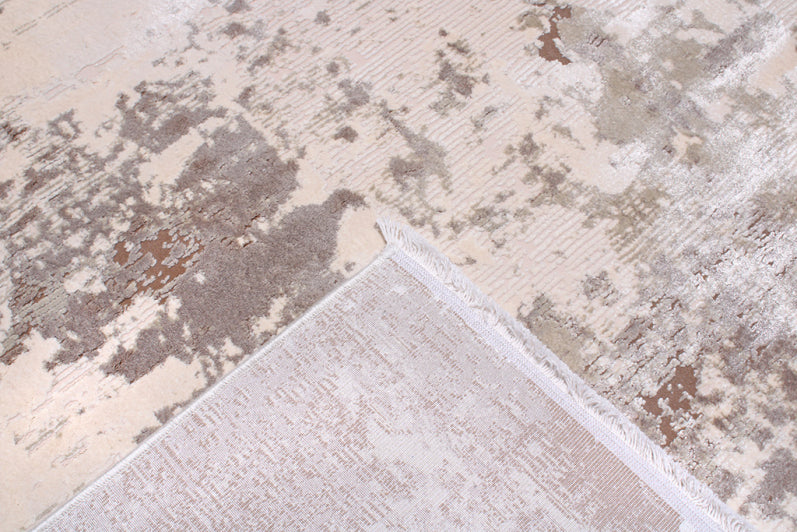 Abstract patterned rug with beige and brown colors showing front and back