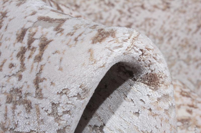 Close up of rolled beige and brown patterned rug texture