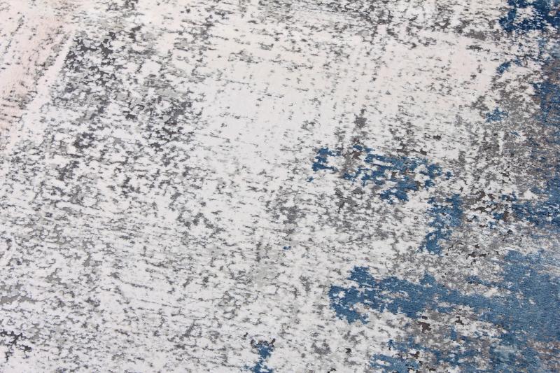 Close-up of the Luzione 857 modern area rug featuring an abstract design in blue, gray, and white, perfect for adding style to any room