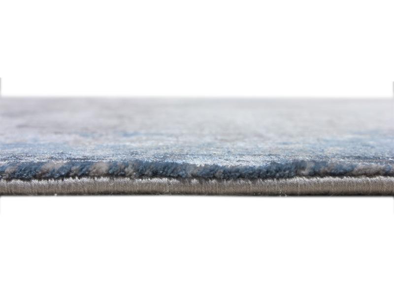 Close-up of a blue and gray Luzione modern area rug showcasing its soft pile, comfortable texture, and abstract design for home decor
