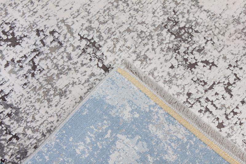 Close-up of the Luzione 857 modern area rug featuring an abstract design in blue and gray, perfect for contemporary home decor