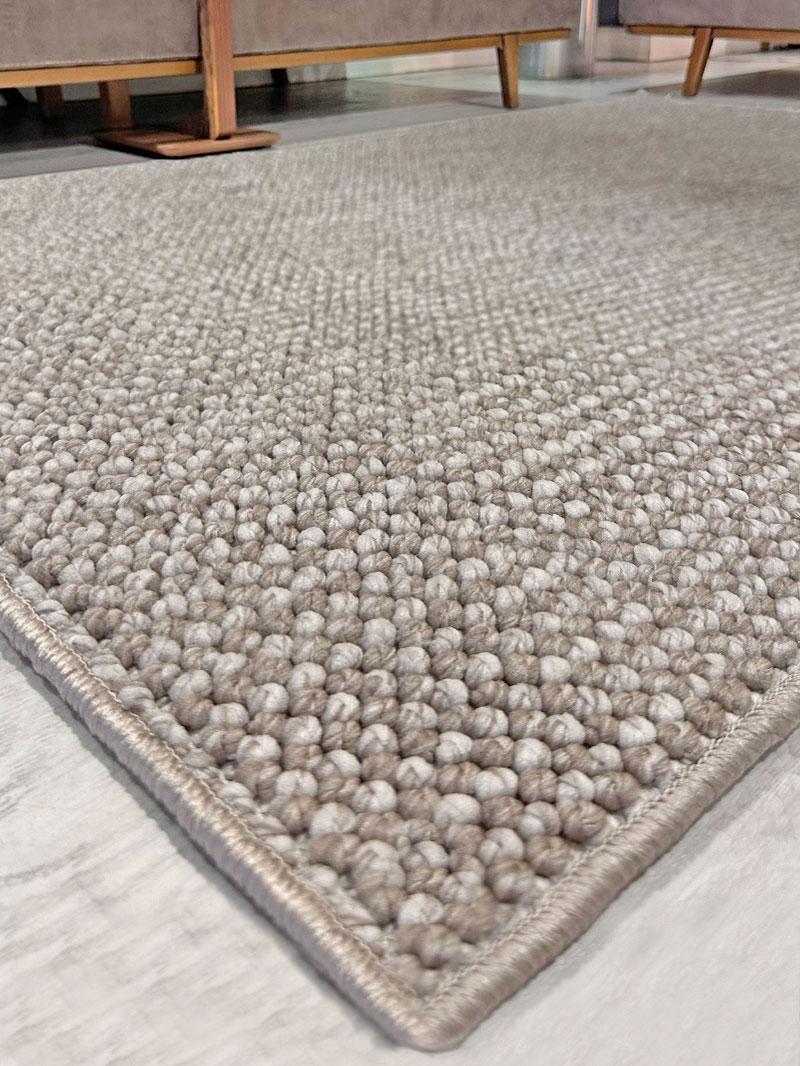 Close up view of beige textured area rug on floor