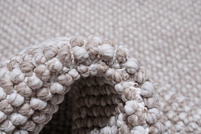 Close up view of beige and white bobble texture rug