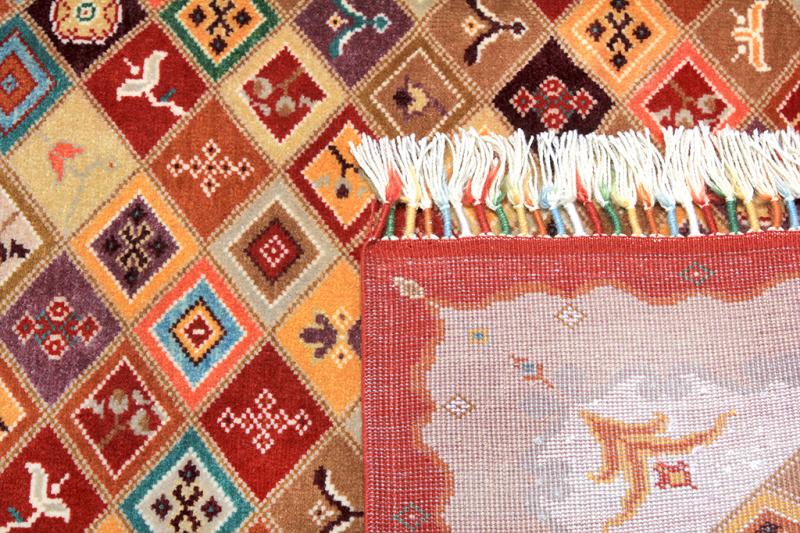 Close up view multicolored patterned rug with fringe and backing