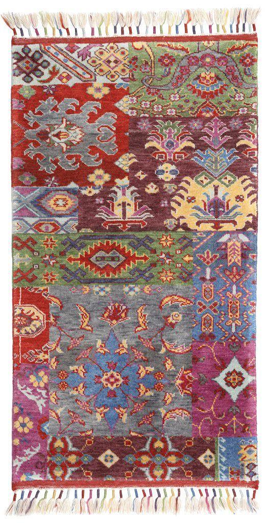 Colorful patchwork area rug with tassels on white background