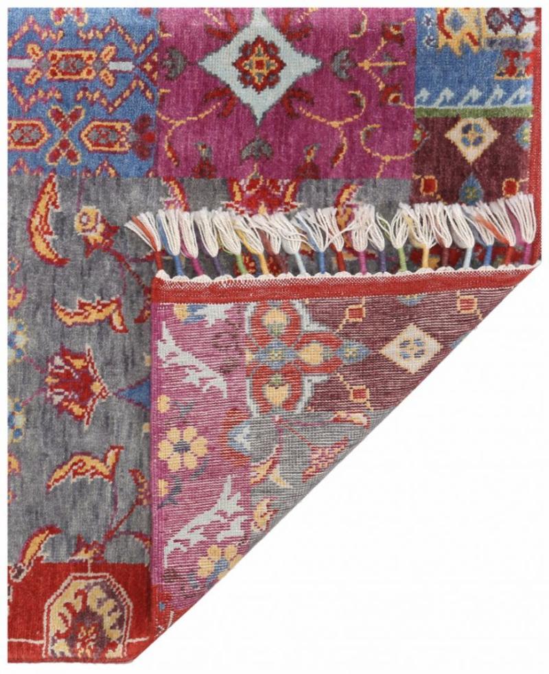 Close up view of colorful patterned rug with fringe showing underside