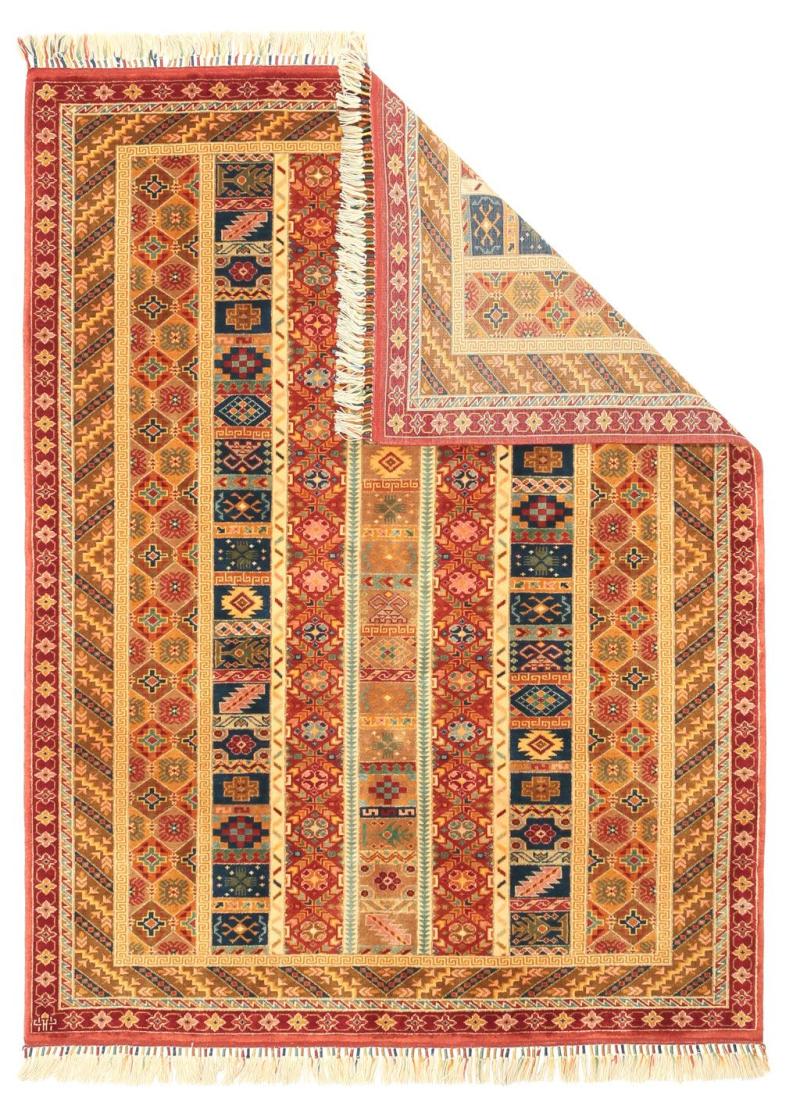 Overhead view of colorful patterned area rug with fringe