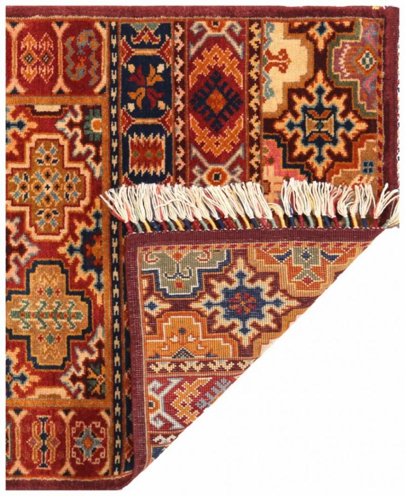 Close up view of colorful patterned rug with fringe showing underside