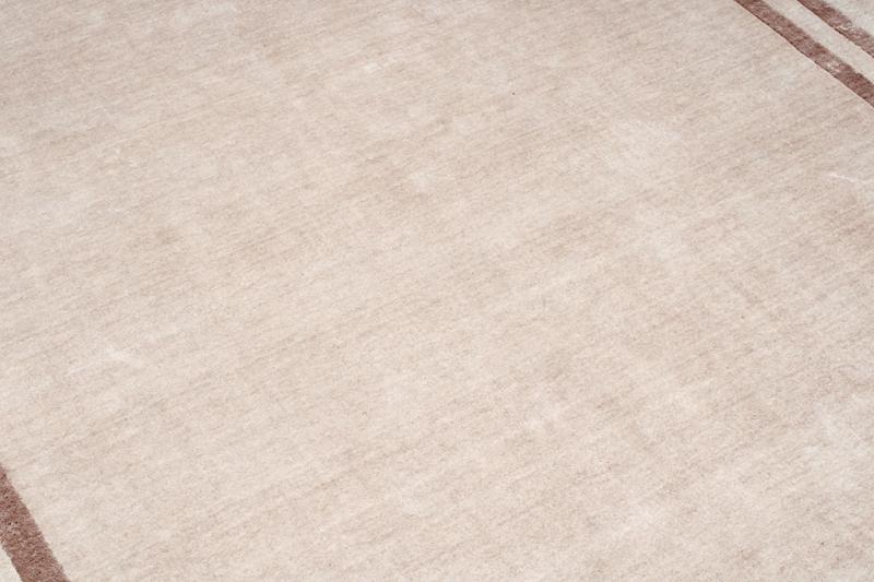 Close-up of the Cornelli Rug's beige fibers, showcasing its soft texture and ability to complement various decor styles.