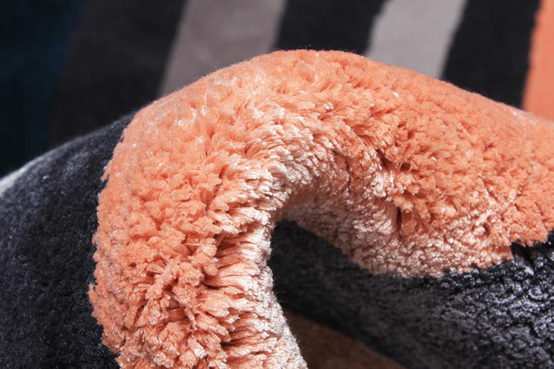 Close up view of orange and black striped rug texture