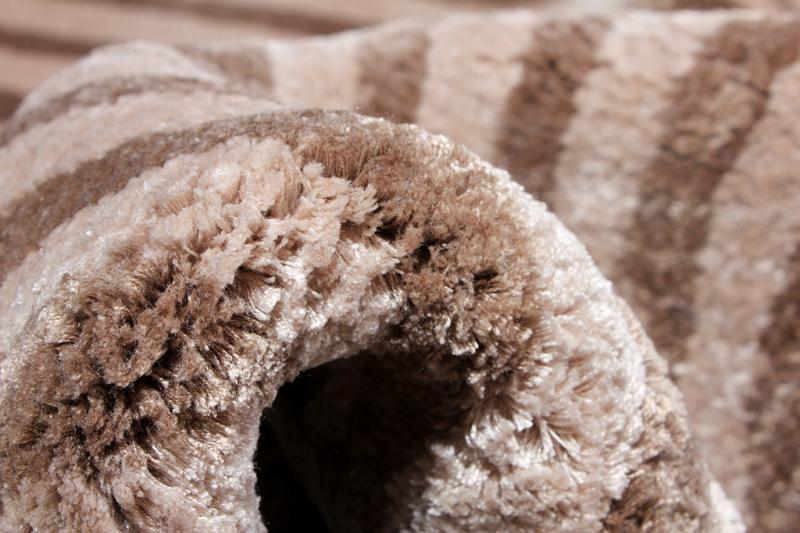 Close-up of the Luzione 906 Trace Tufted Rug. Beige and brown stripes create a soft, plush, modern, and luxurious shag carpet texture