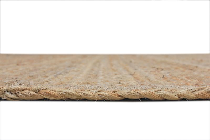 Close up view of braided jute rug edge against white background.
jute rug, braided edge, natural fiber, area rug, floor covering, home decor, woven rug, close up, texture, beige rug, sisal rug, braided jute rug