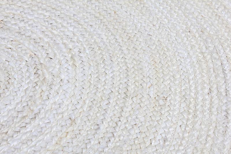 Close-up of woven Zora rug texture showing braided pattern in bleach tone.