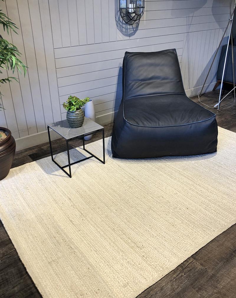 Interior view of a Luzione 910 Urban Rug paired with a black leather bean bag chair and sleek side table, enhancing a contemporary living space