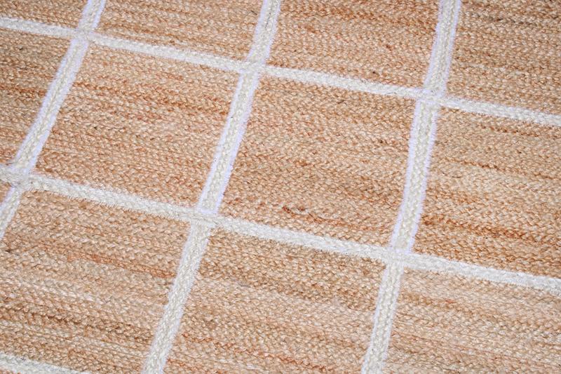 Close up view of natural fiber rug with white grid pattern