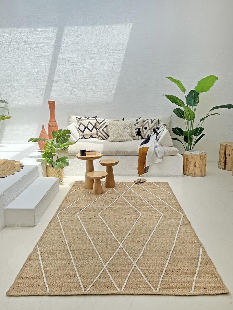 Bohemian living room with jute rug, sofa, and wooden stools.