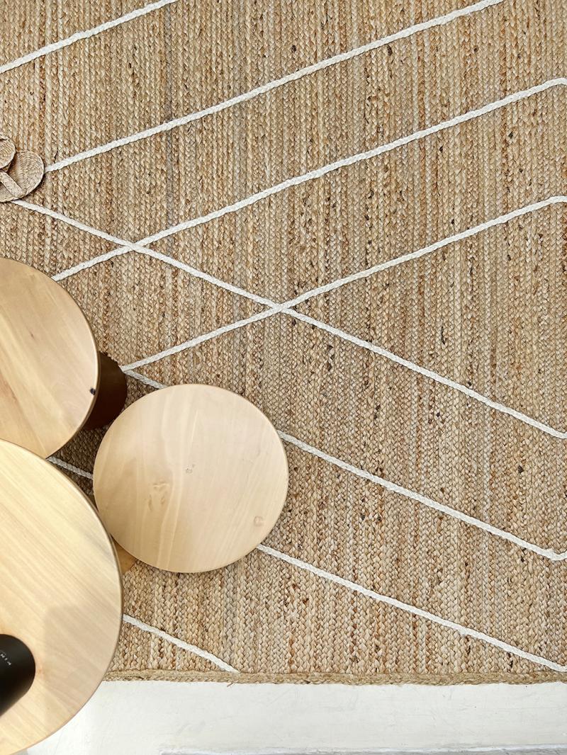 Jute rug with white lines, light wood round tables.