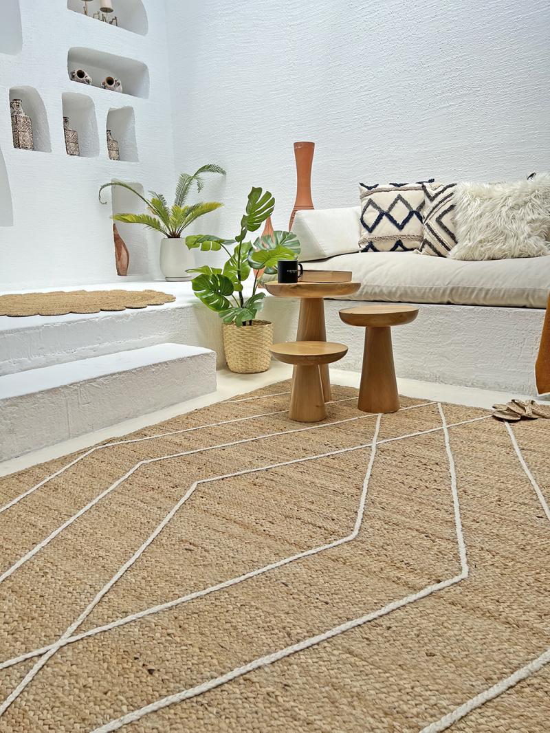 Indoor view of jute rug with white geometric pattern and wooden tables