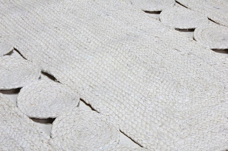Close up view of white braided jute rug with circular cutouts