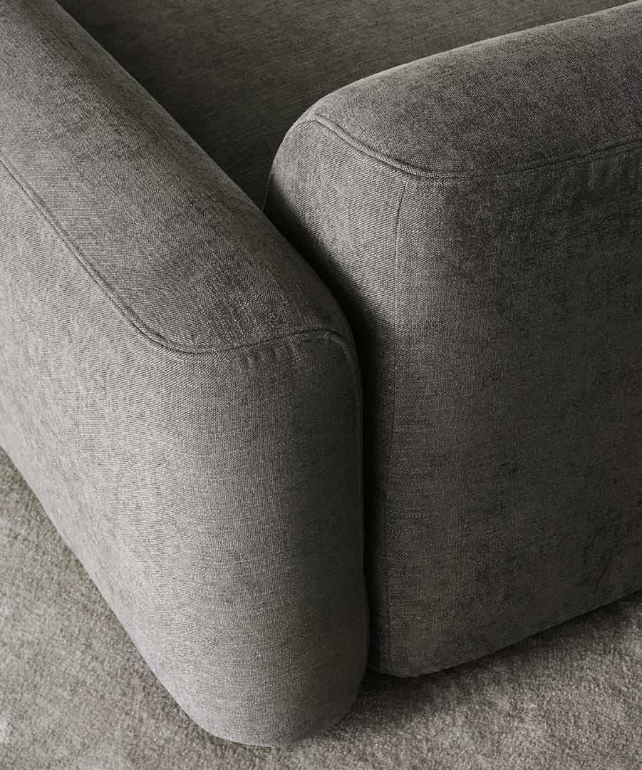 Close-up of the modern gray Botero sofa by Casamilano, highlighting its sleek armrests and the soft, durable fabric upholstery