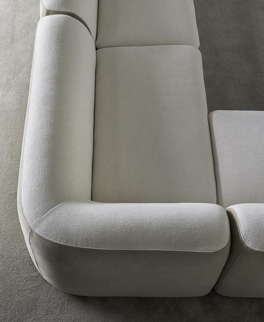 High-angle close-up of the Casamilano Botero modular sofa, showcasing its light, textured fabric, rounded edges, and seamless, modern design