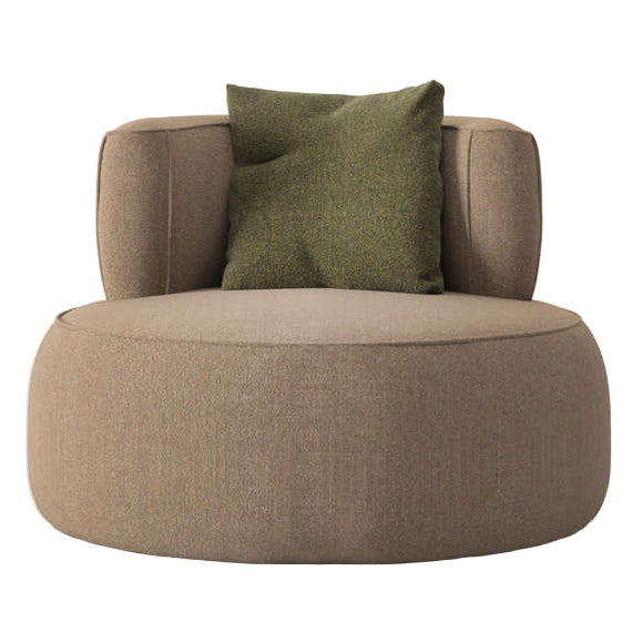View of a round brown upholstered chair with a green pillow on a white background.
