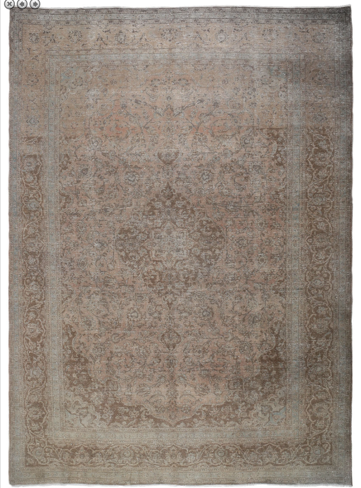 A large, brown Persian rug with traditional geometric patterns and a central Medallion design.