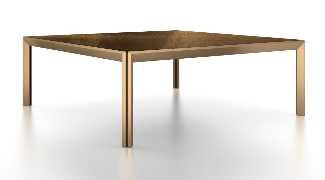 View of square bronze coffee table on white background.