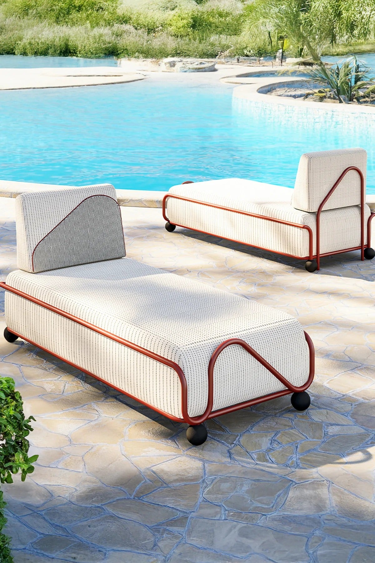Two white outdoor chaise lounges with red frames by a pool