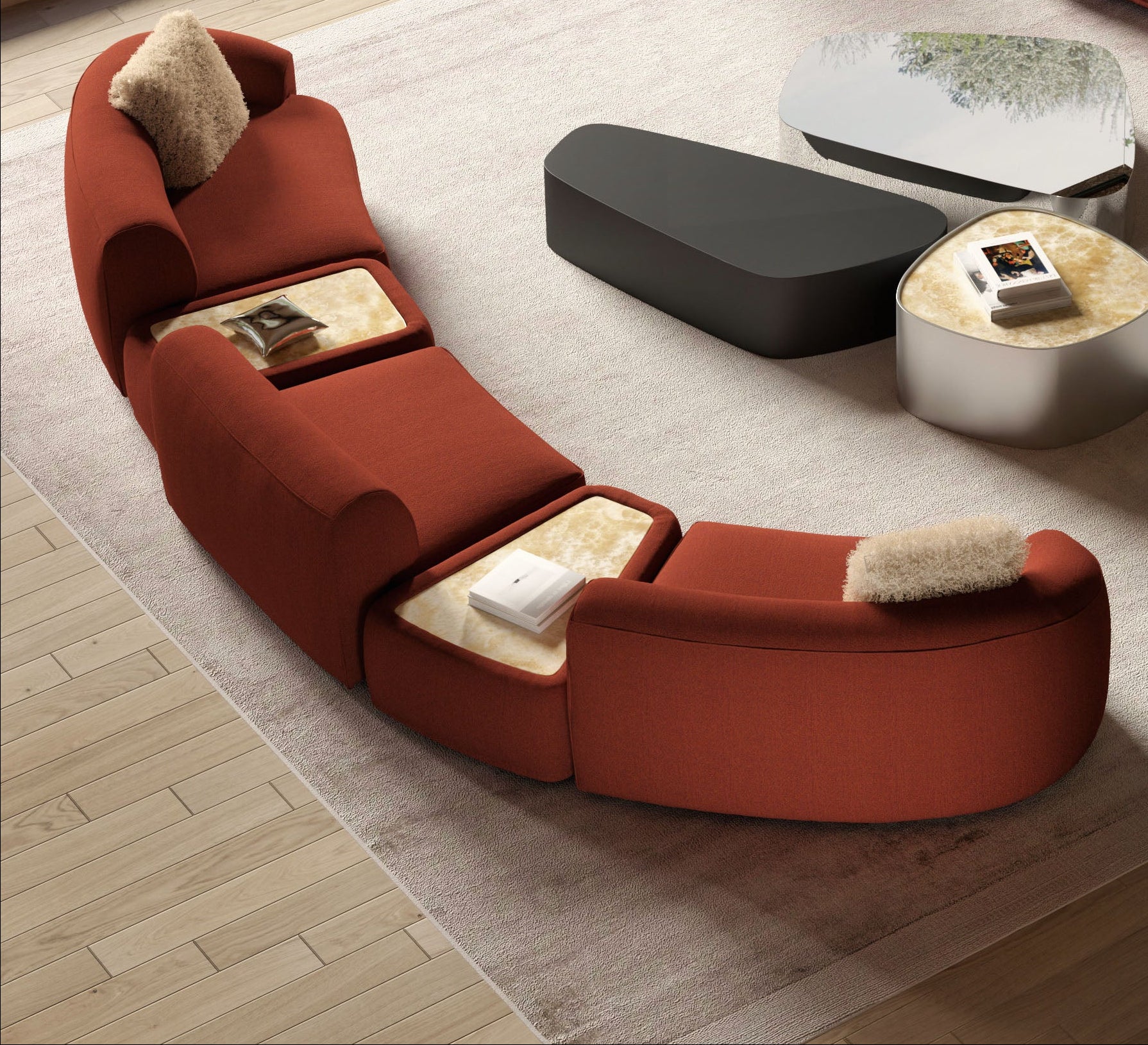 High angle view of curved red modular sofa and coffee tables on rug.
