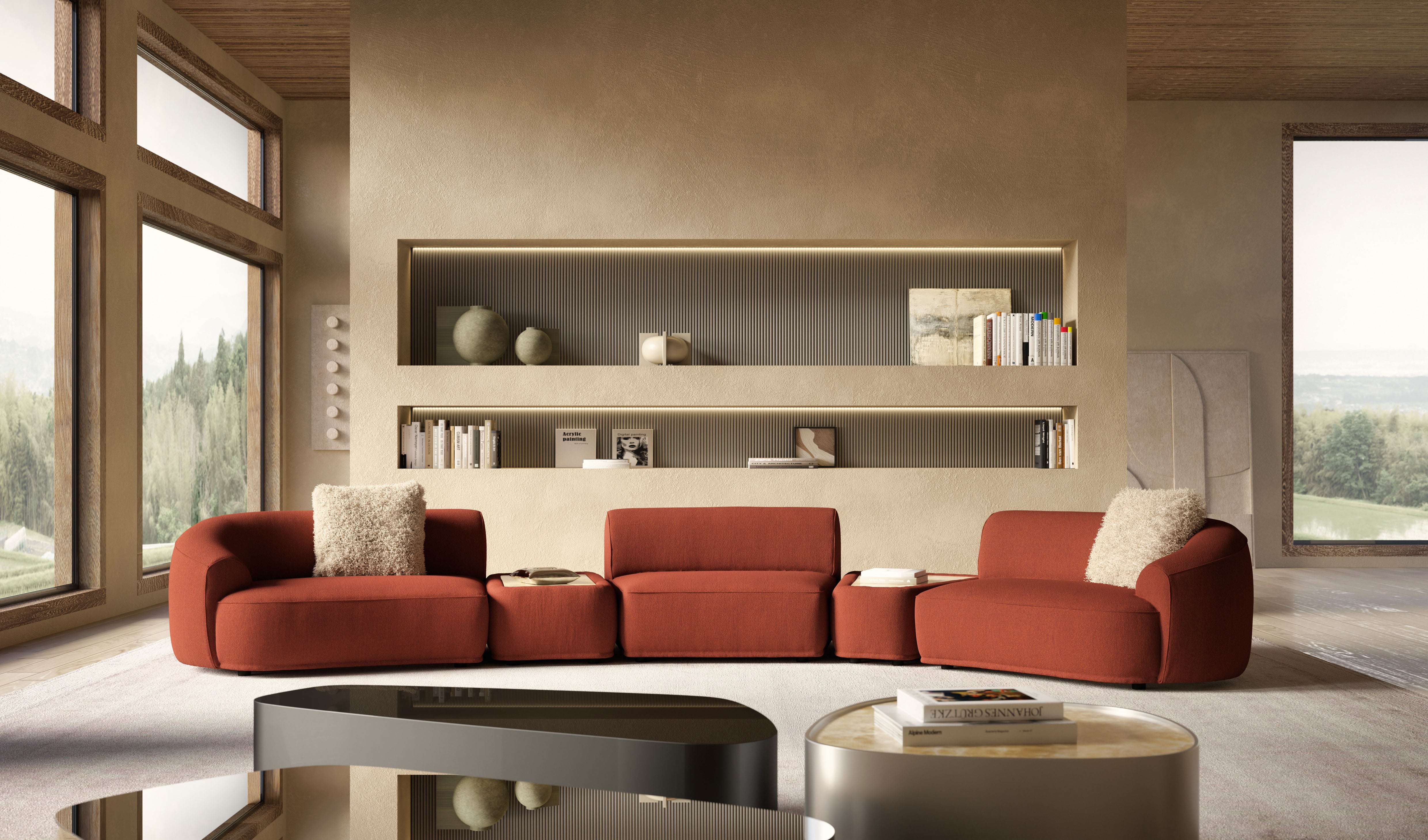 Interior view of large living room with red modular sofa, coffee tables, built-in shelving, and large windows overlooking a forest.