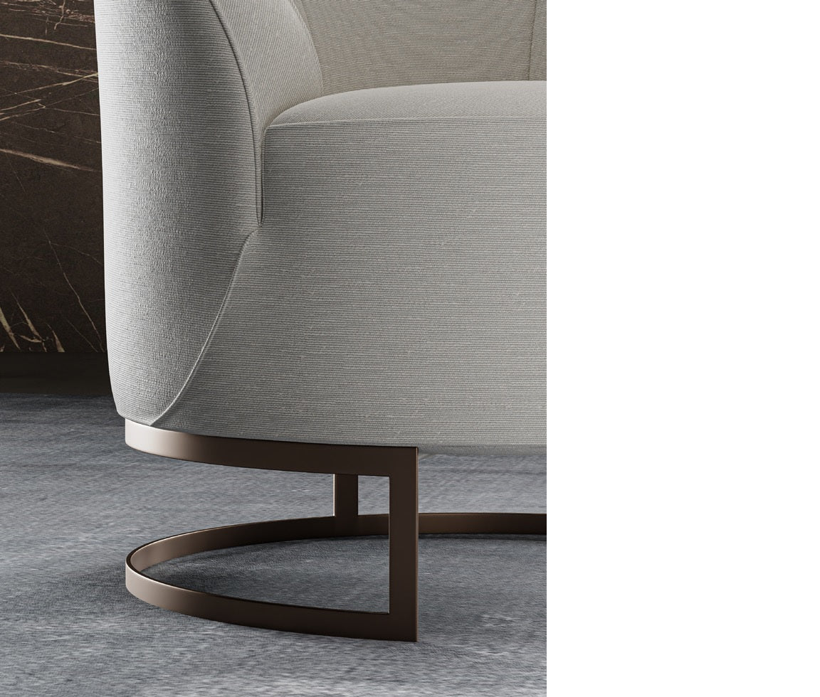 Close up of beige fabric armchair with bronze metal base
