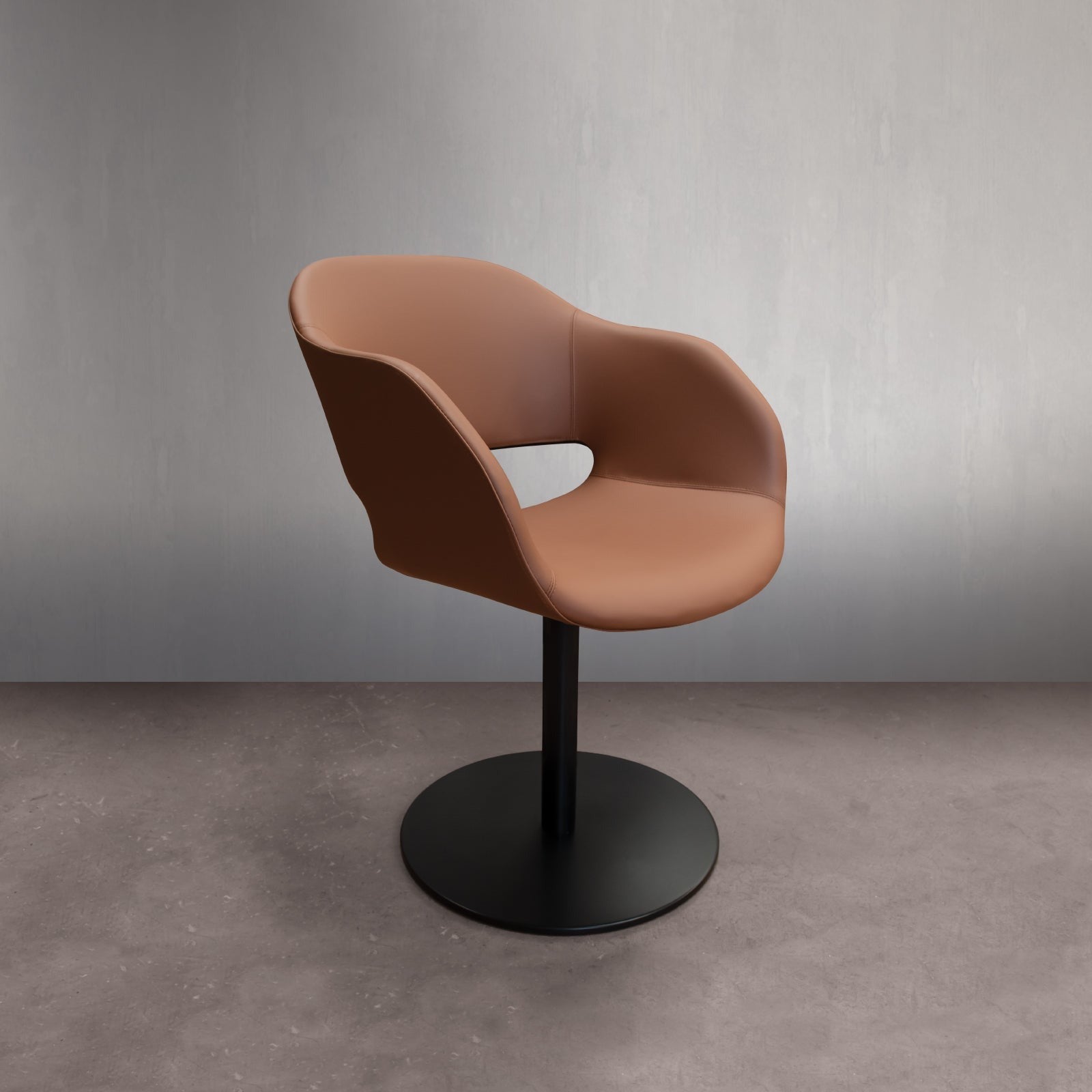 View of modern tan leather chair on black pedestal base.