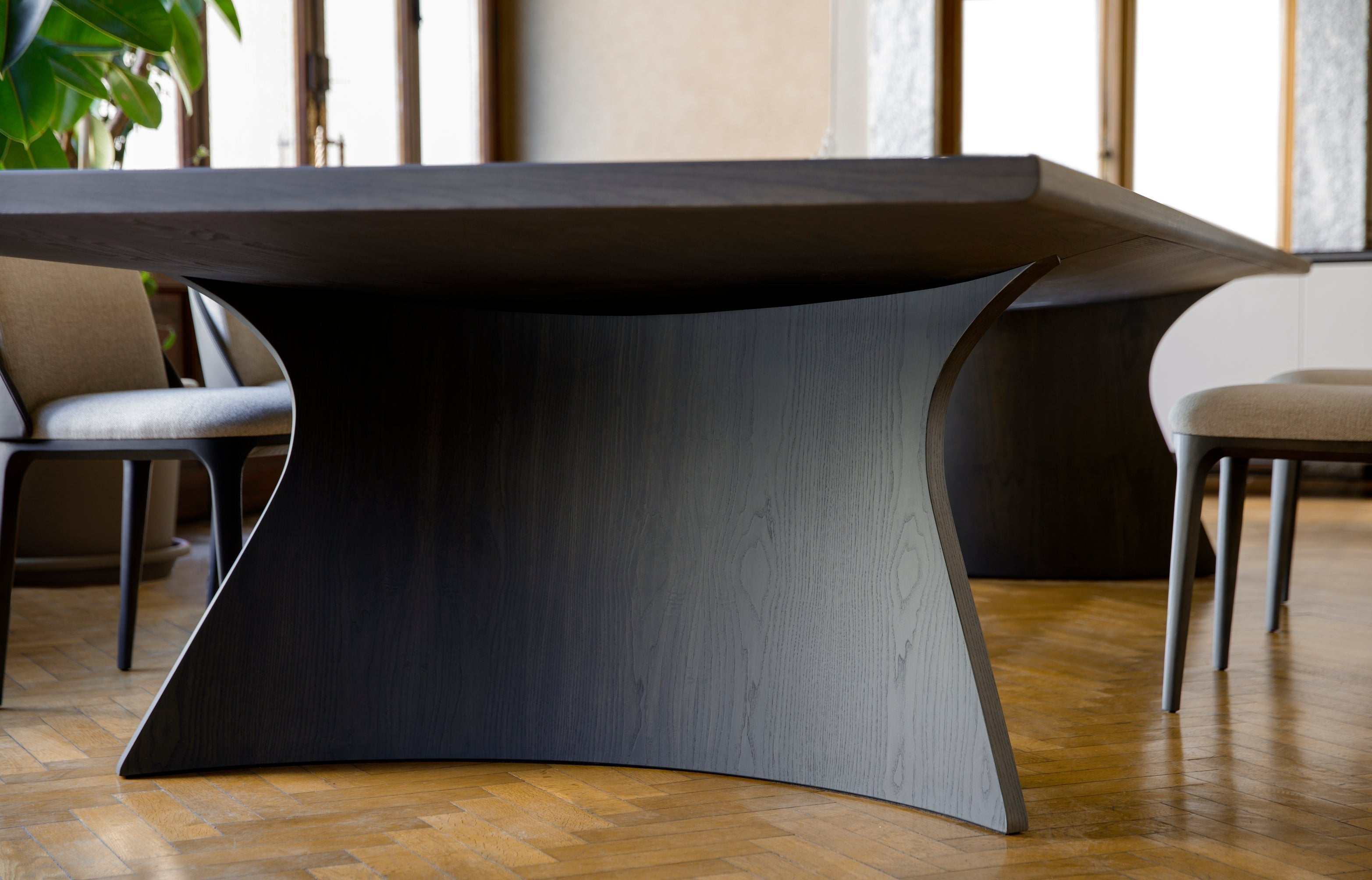 Close up dark wood dining table base curved shape