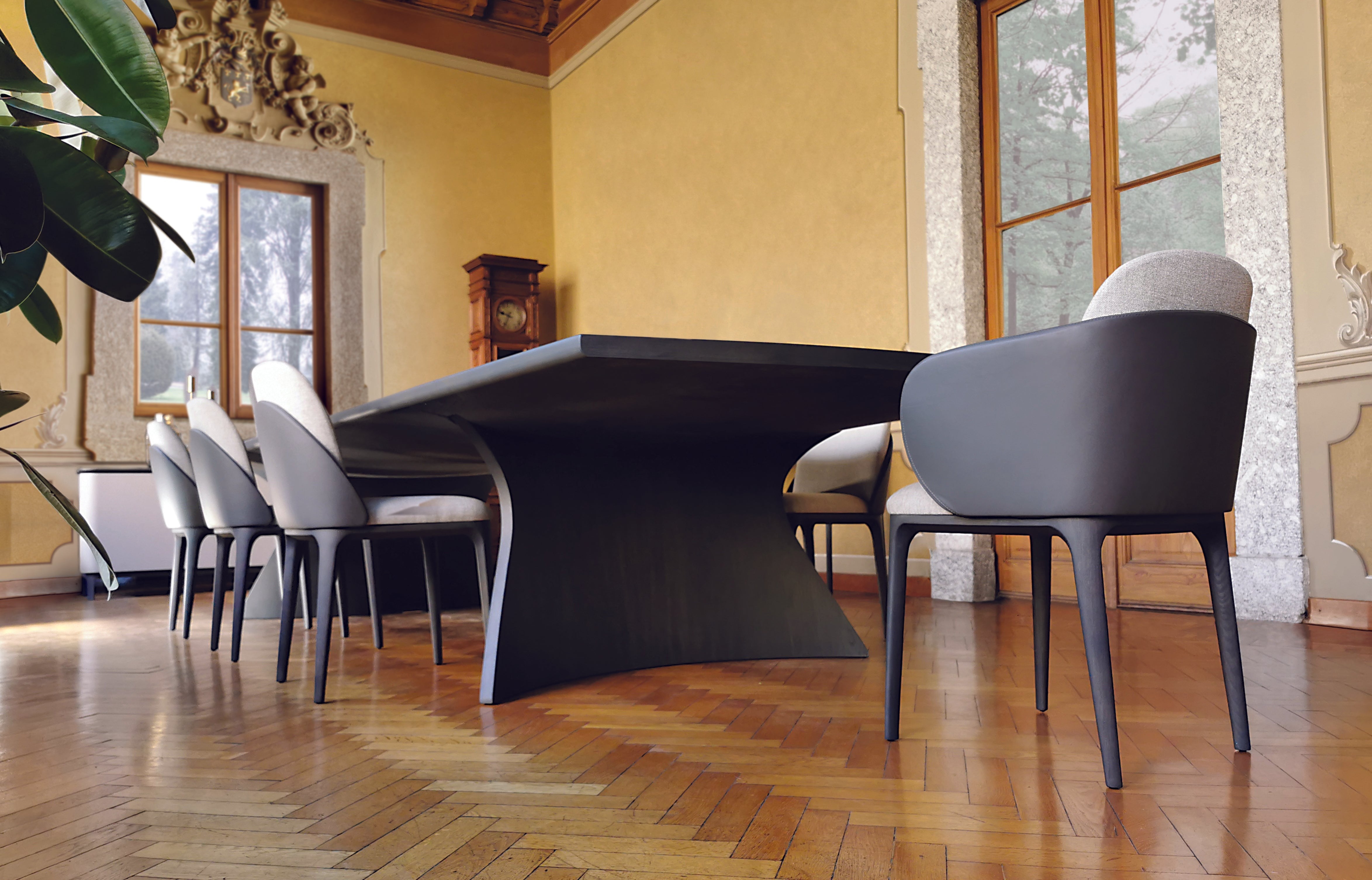 Dining room with black wood table and gray chairs, wood floor.