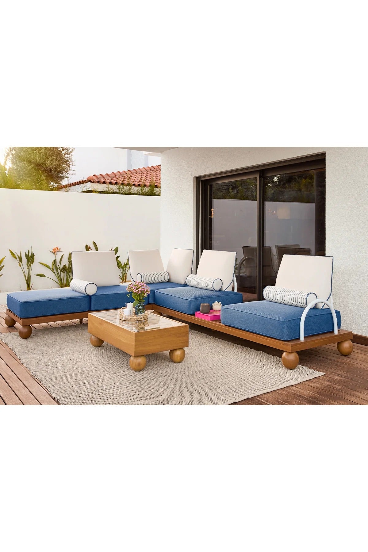 Outdoor patio furniture set with blue cushions and a wooden coffee table on a patio.