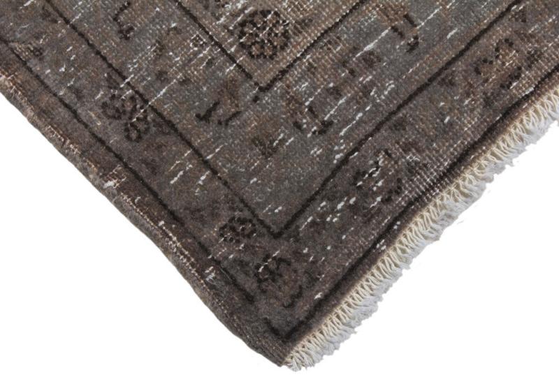 Close-up brown area rug corner with fringe detail