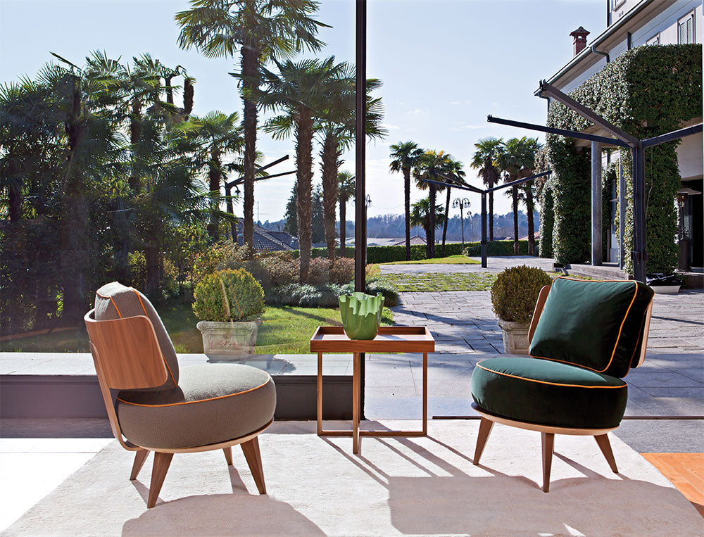 View of two upholstered chairs and wood side table on rug