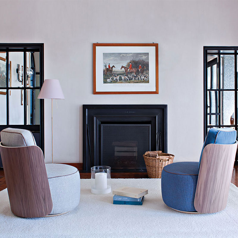 Living room with two wood and fabric armchairs facing fireplace